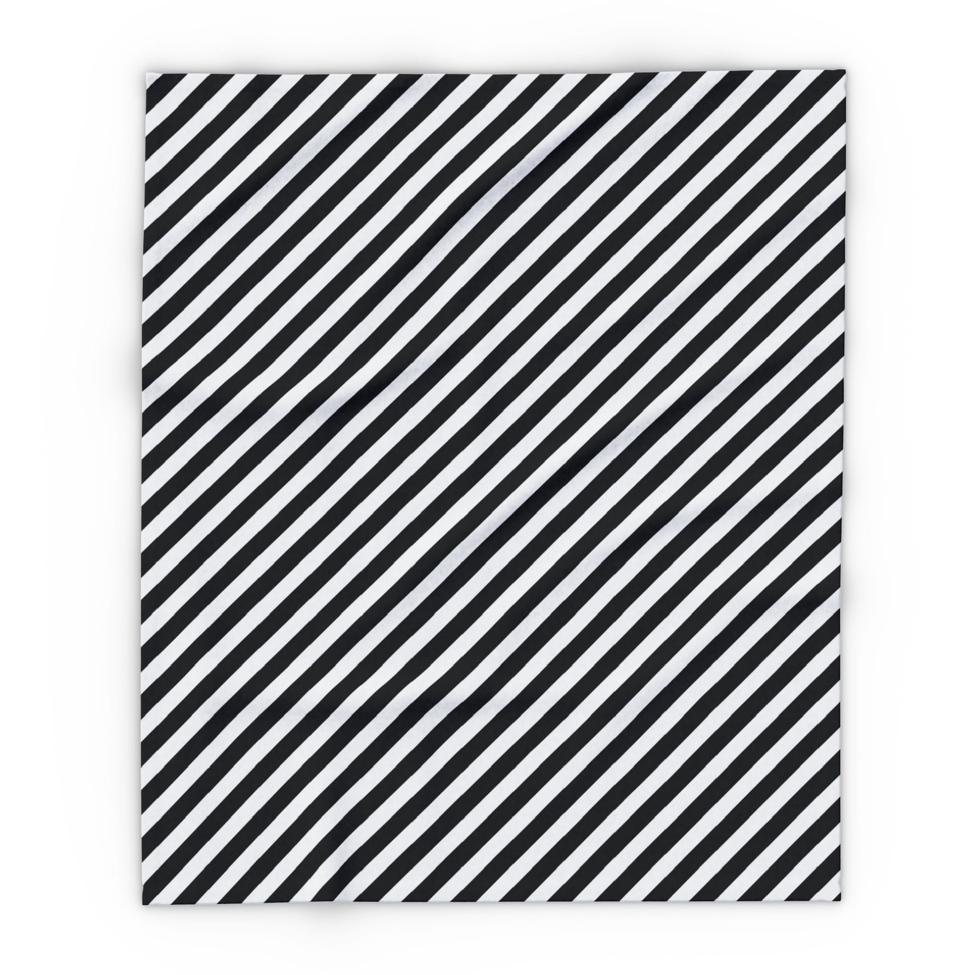 Black and white striped outdoor fleece blanket draped over a chair on a patio