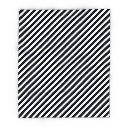 Black and white striped outdoor fleece blanket draped over a chair on a patio