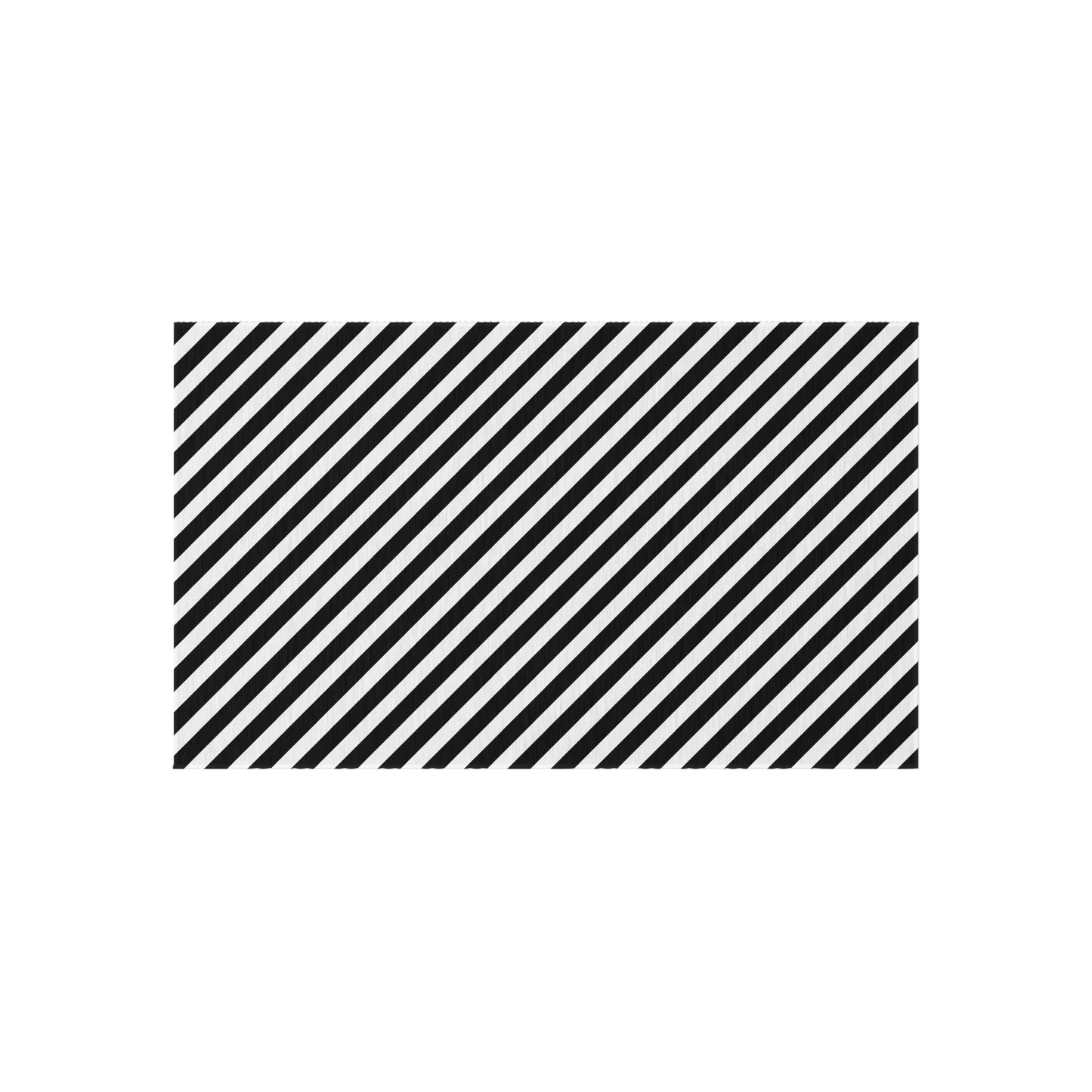Black and white striped outdoor rug shown on decking beside patio furniture