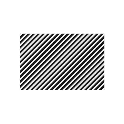 Black and white diagonal striped outdoor rug on a patio — soft polyester chenille with non-slip backing