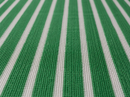Close-up of the green and white striped outdoor rug — short, dense low-pile chenille nap