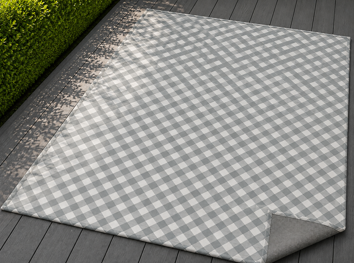 Grey diagonal gingham outdoor rug with the corner folded back — matte grey non-slip backing