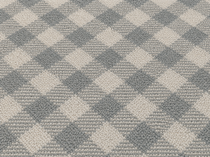 Close-up of the grey diagonal gingham outdoor rug — short, dense low-pile chenille nap