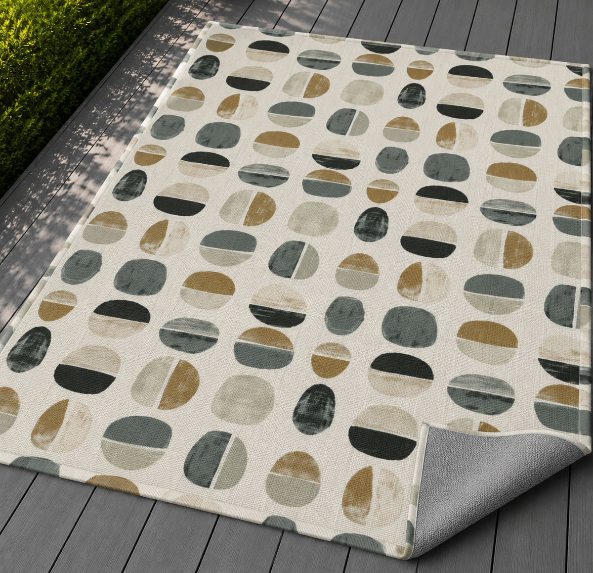 Grey split pebble outdoor rug on a patio — soft polyester chenille with a non-slip backing