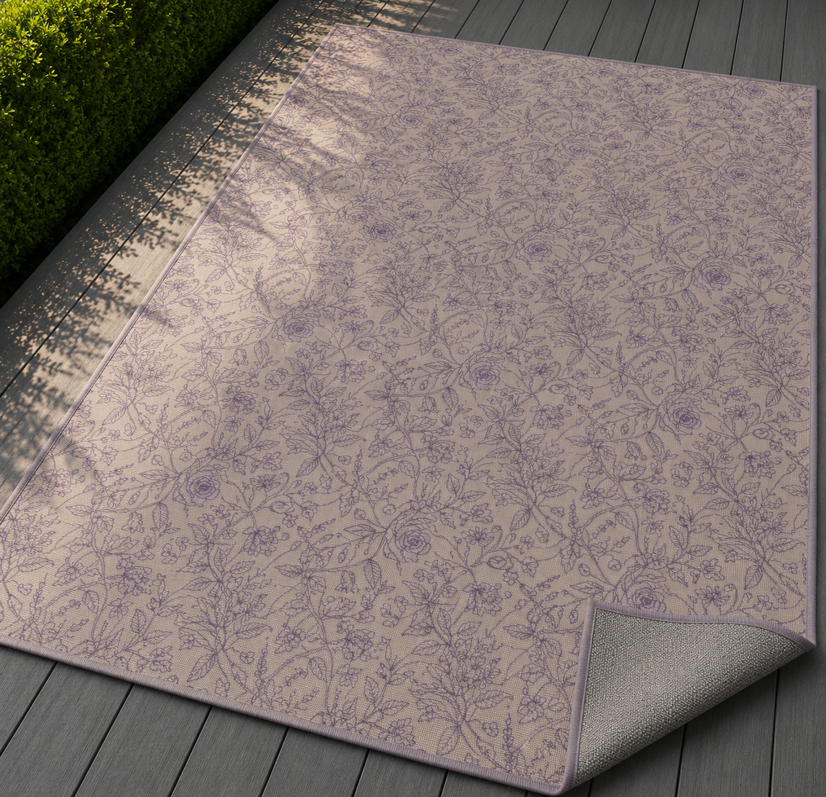Mauve rose vine outdoor rug with the corner folded back — matte grey non-slip backing