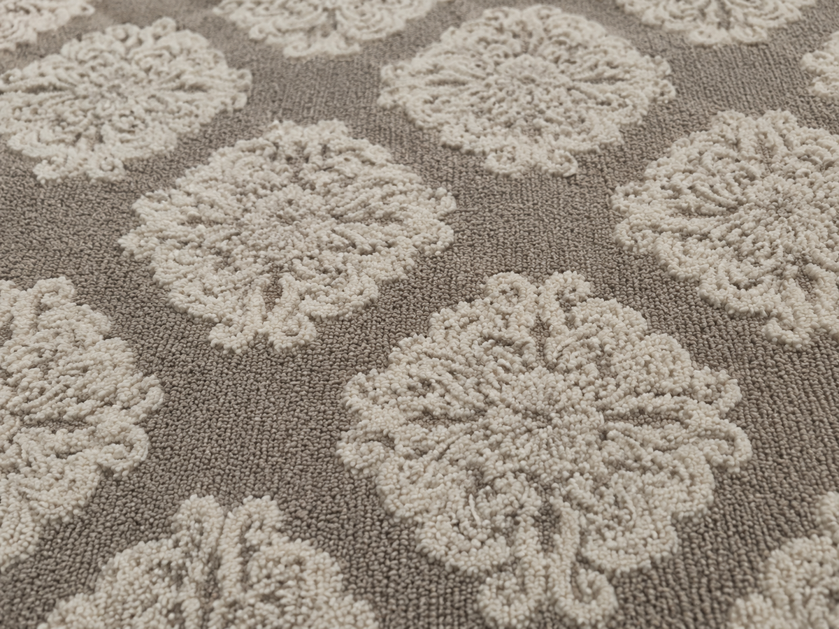 Close-up of the taupe damask outdoor rug — short, dense low-pile chenille nap