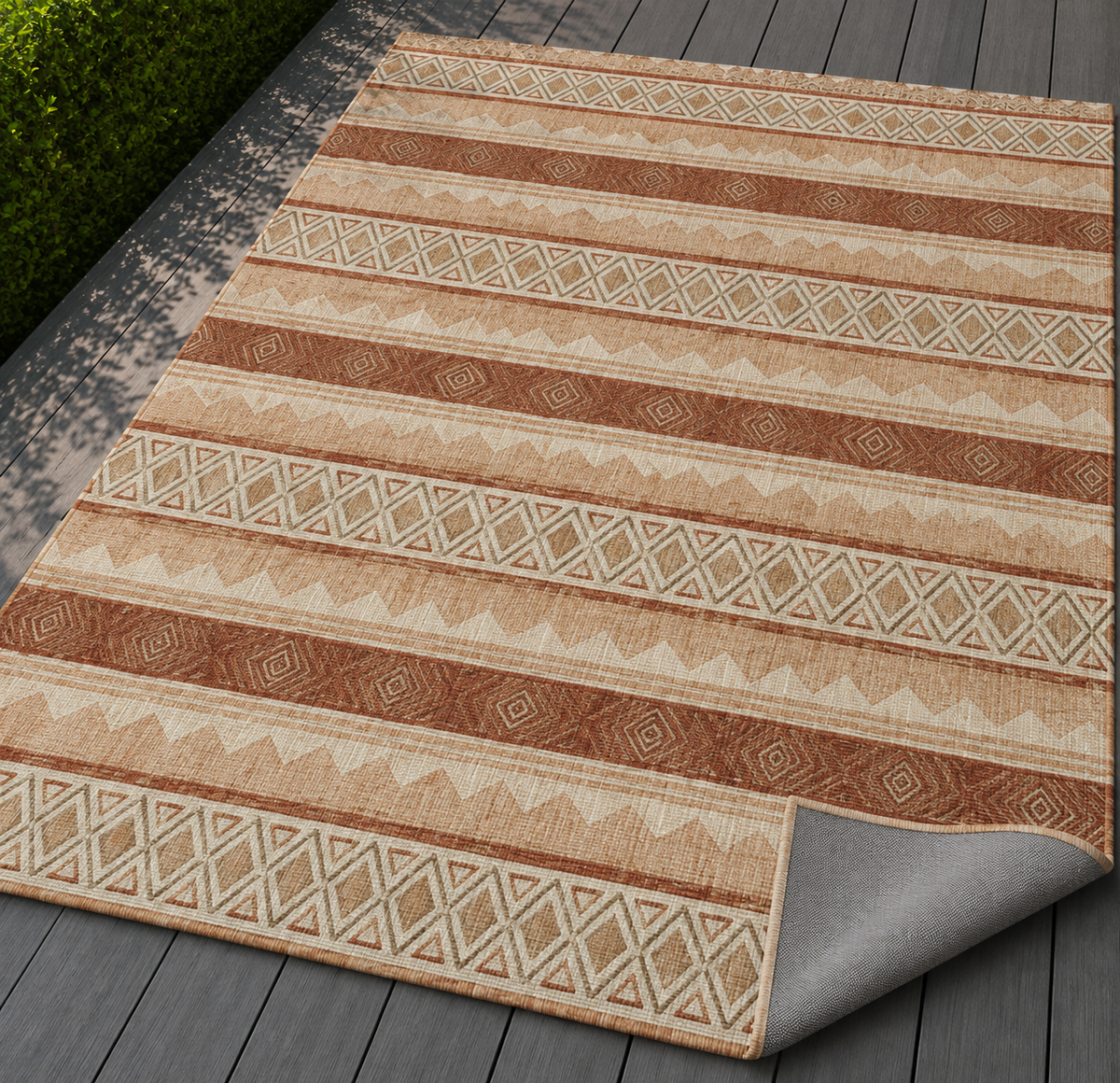 Terracotta kilim outdoor rug with the corner folded back — matte grey non-slip backing