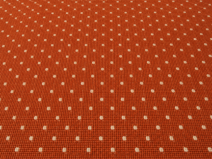 Close-up of the terracotta pin dot outdoor rug — short, dense low-pile chenille nap